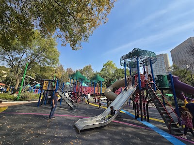 Niños jugando en una de las áreas de juegos infantiles del Parque Lincoln, con resbaladillas de colores.
